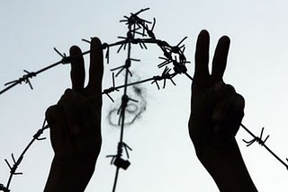 symbole de victoire sur l'oppression image de deux mains faisant signe de victoire devant barbelés