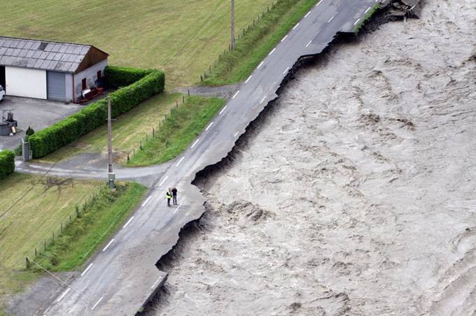 exemple des conséquences du dérèglement climatique photo d'une route bitumée défoncée par une crue