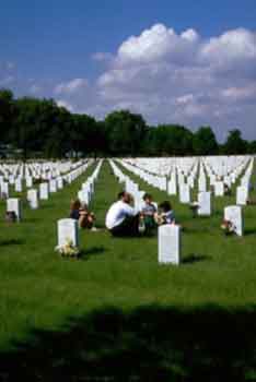 Pour souvenir des guerres en Europe du temps jadis photo d'une famille se recueillant devant stèle dans un cimetière militaire