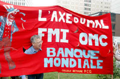 évocation de la financiarisation de l'économie et mondialisation des échanges. photo d'une banderole de manifestants mentionnant Axe du Mal : FMI, OMC, Banque Mondiale.