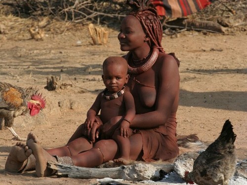 La femme est l'avenir de l'homme...celui de l’humanité. Hommage et respect à toutes les femmes des cinq continents. Photo de jeune femme africaine, Namibie, assise, tenant enfant sur ses jambes.