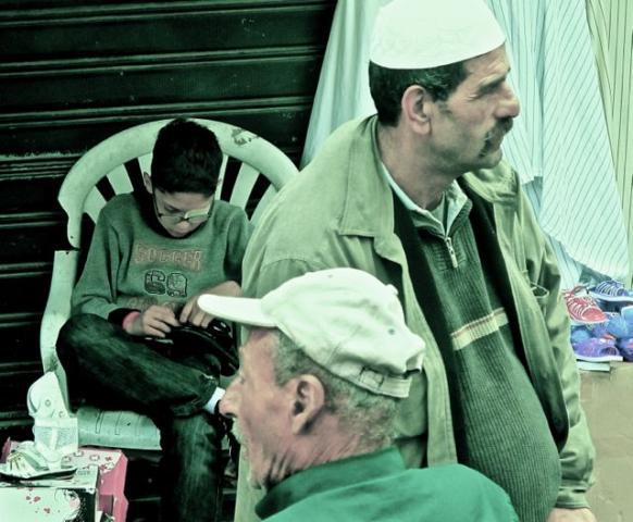 enfant blessé et adultes inquiets à Gaza, été 2014 photo enfant borgne, assis bricolant chaussure, et adultes inquiets