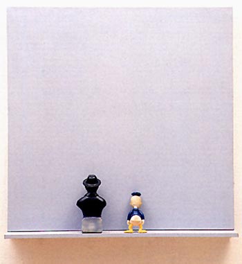 À chaque coup de feu un camarade renaît. Et dans la bouche un goût de Révolution. image de statuettes, buste noir et citoyen lambda, sur rebord devant tableau gris.