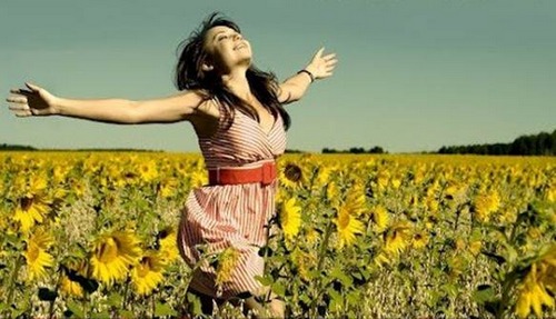 Notre vie...seulement une saison...sous le soleil...Jouer la vie, l'amour ...avant que le froid de la nuit efface... photo de jeune femme heureuse, marchant bras ouverts, dans un champ de tournesols.