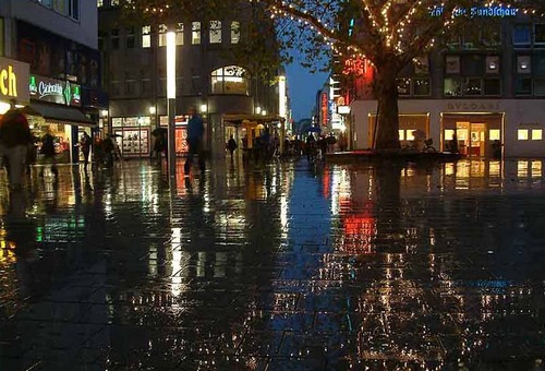 place citadine, claire par commerces, vue de nuit avec reflets sur pluie